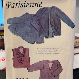 May include: A sewing pattern package labeled "Parisienne" with illustrations of a sleeveless blouse, jacket, and tunic. The text reads "The sleeveless blouse, with a bias cowl neckline, is paired with a French inspired jacket or easy tunic." The pattern number is #326.