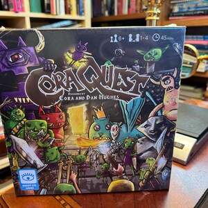 Könnte beinhalten: Eine quadratische Brettspielschachtel mit dem Titel CoraQuest, entworfen von Cora und Dan Hughes. Das Cover zeigt bunte Cartoon-Monster, Skelette und Krieger in einem Dungeon. Symbole zeigen 6+ Jahre, 1-4 Spieler und 45 Minuten Spielzeit an.