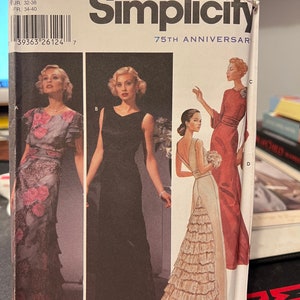May include: Simplicity sewing pattern for three different dresses. The pattern is for sizes 6, 8, 10, and 12. The dresses are all floor-length and have different styles. The first dress is a floral print, the second is a black dress with a scoop neck, and the third is a white dress with a tiered skirt.