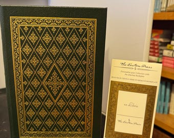 May include: A green hardcover book with a gold embossed design on the front cover. The book is titled "The Easton Press" and has a bookplate that says "ex Libris".
