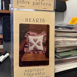 May include: A pattern for a pillow featuring a heart design. The pattern is titled "HEARTS" and includes instructions for applique, trapunto, and candlewicking.