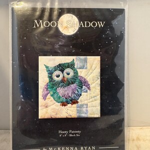 Może przedstawiać: Wzór do pikowania przedstawiający kolorowego sowa z tytułem "Moon Shadow" i tekstem "Hooty Patootie 8" x 8" - Block Six by MCKENNA RYAN".