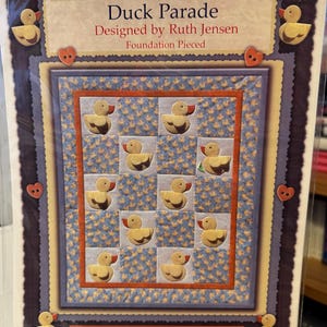 May include: A quilting pattern for a quilt featuring a duck parade. The pattern is called "Duck Parade" and is designed by Ruth Jensen. The pattern is foundation pieced. The pattern is from Thimble Art.
