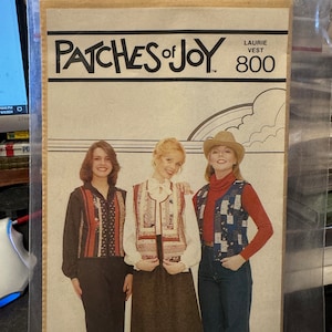 May include: A vintage sewing pattern for a vest, titled "Patches of Joy" with the number 800. The pattern features three women wearing different vests, one with a red and white striped vest, one with a floral vest, and one with a blue and white checkered vest.