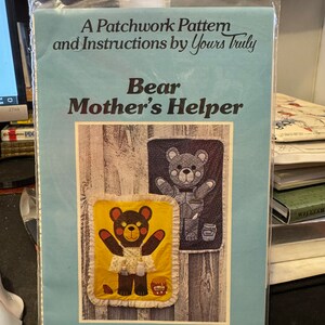 Op de afbeelding: Een patchwork-patroon en instructies voor een "Bear Mother's Helper" -deken. Het patroon toont twee beren, een in blauw en een in bruin, met een afgewerkte maat van 58 cm bij 84 cm. Het patroon is van Yours Truly, Inc. en werd in 1979 in de VS gemaakt en gedrukt.