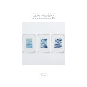 May include: Three rectangular acrylic frames containing woven textile art with blue and white wave patterns. The text Wave Weaving is at the top and 6 e.p.i is at the bottom. Each piece features layered blue threads creating abstract water-like designs.