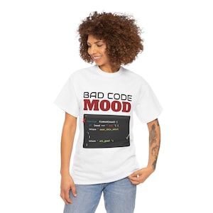 Könnte beinhalten: Weißes T-Shirt mit dem Text "BAD CODE MOOD" in Burgunderrot. Darunter befindet sich eine Grafik mit Code und dem Text "wear_this_shirt". Das T-Shirt wird von einer Person mit lockigem Haar und Jeans getragen.