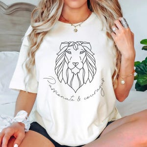 May include: White t-shirt with a line drawing of a lion's head and the text "Passionate & Courageous".