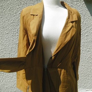 May include: A brown wrap dress with a long sleeve and a deep V-neckline. The dress is made of a soft, flowing fabric and has a cinched waist.