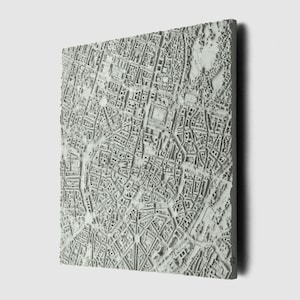 Pode incluir: Um mapa 3D de uma cidade, impresso em 3D, mostrando o layout das ruas e edifícios. O mapa é feito de um material cinza claro e tem uma superfície texturizada.