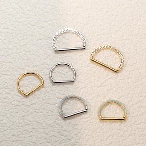 Puede incluir: Seis estilos diferentes de anillos de nariz con una barra con bisagras. Los anillos están hechos de plata y oro y presentan piedras transparentes y de ópalo.