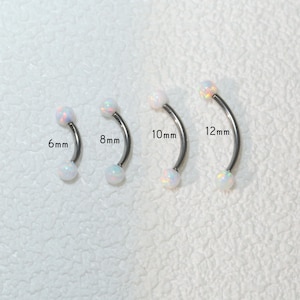 Peut inclure: Quatre boucles d'oreilles en forme de barre incurvée argentées avec des boules d'opale blanche. Les boucles d'oreilles sont présentées en tailles 6 mm, 8 mm, 10 mm et 12 mm.