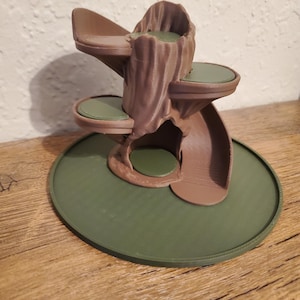 May include: A brown and green cat tree with multiple platforms and a tree trunk design. The cat tree has a circular base and several levels for climbing and resting. The platforms are green and the tree trunk is brown.