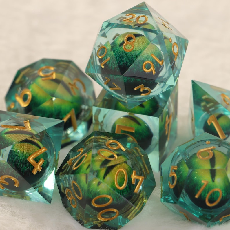 K&ouml;nnte beinhalten: Eine Sammlung von W&uuml;rfeln mit einem t&uuml;rkis-gr&uuml;nen Design. Die W&uuml;rfel haben goldfarbene Zahlen und ein detailliertes Innenmuster. Das Set enth&auml;lt verschiedene Formen, wie D20, D6 und D4, geeignet f&uuml;r Tabletop-Spiele.