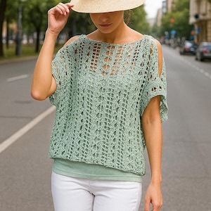 Peut inclure: Un haut en crochet vert clair à tissage ouvert, avec des manches courtes et un col bateau. Le haut est associé à un chapeau de paille et à un pantalon blanc. La tenue est adaptée aux climats chauds et aux occasions décontractées.