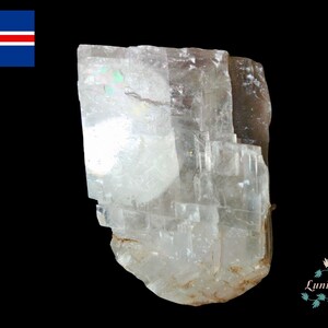 May include: A clear, translucent crystal with a layered, striated texture. The crystal has a slightly off-white hue and is irregularly shaped.