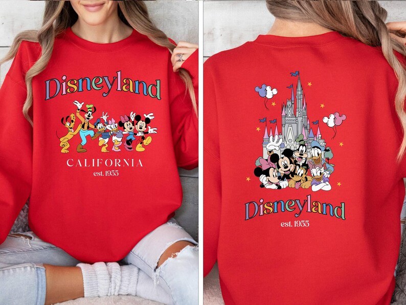 Puede incluir: Sudadera roja con un logotipo de Disneyland colorido y un gr&aacute;fico de Mickey Mouse y sus amigos. La parte posterior de la sudadera tiene un gr&aacute;fico del castillo de Disneyland y Mickey Mouse y sus amigos.