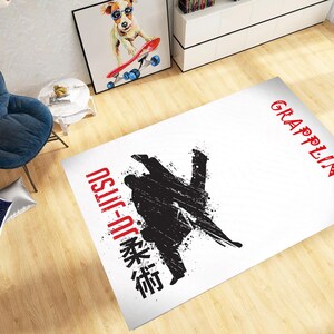 May include: White rectangular rug with a black and red Jiu-Jitsu design. The rug features a stylized silhouette of two grappling figures, with the words "Jiu-Jitsu" and "Grappling" in red and black.