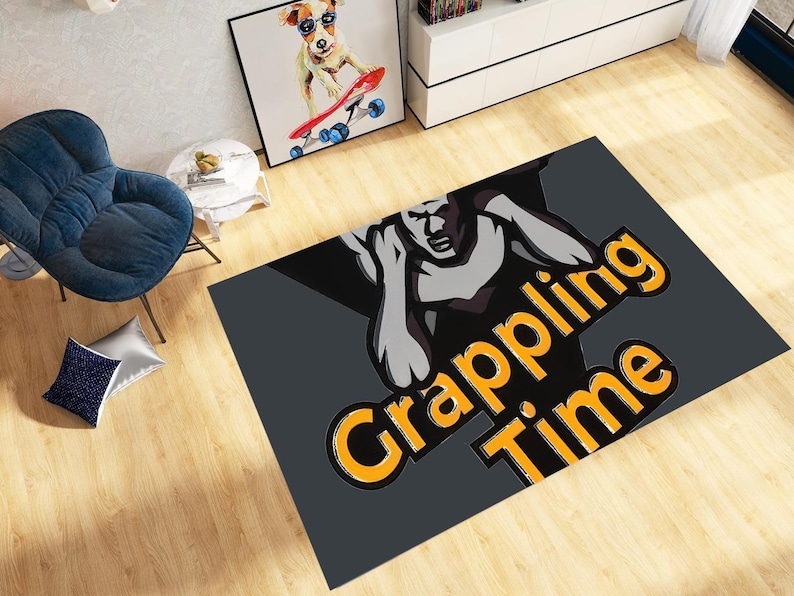 May include: A rectangular grey rug with the words "Grappling Time" in orange and black. The rug features a stylized illustration of a muscular figure in a grappling pose. The rug is on a wooden floor.
