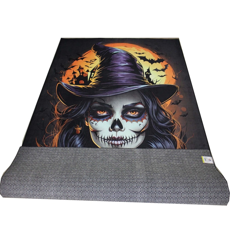 May include: A Halloween-themed rug with a colorful illustration of a witch with a skull face and a purple hat. The witch is in front of a large orange moon with bats flying around it.