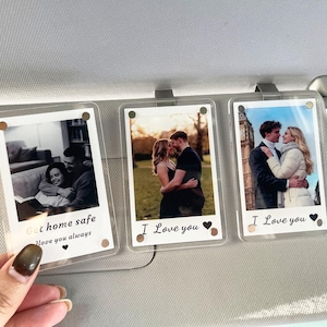 May include: Three clear photo holders with images of couples, each with a metal clip. The photos have the text "Get home safe I love you always", and "I Love you" with a heart symbol. The photos are in a car.