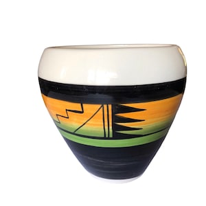 May include: A white ceramic pot with a black, orange, and green geometric design. The pot is shaped like a rounded vase.