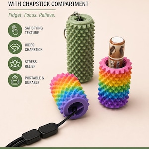 Op de afbeelding: Een verzameling Ouchi Fidgets met chapstick-compartimenten. Eén is groen, een andere is regenboogkleurig en de derde is regenboogkleurig met een chapstick erin. De tekst luidt "Fidget. Focus. Relieve."