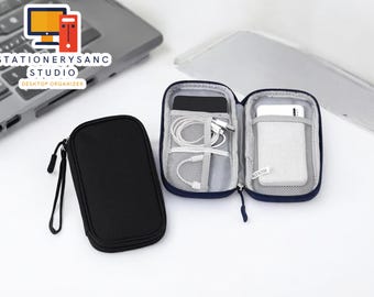 May include: Two black zippered pouches for organizing electronics. One pouch is open and shows a white phone, white charging cables, and a white power bank. The other pouch is closed.