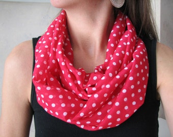 Peut inclure: Une écharpe rouge en forme d'infini avec des pois blancs. L'écharpe est faite d'un tissu doux et léger, parfait pour ajouter une touche de style à n'importe quelle tenue.