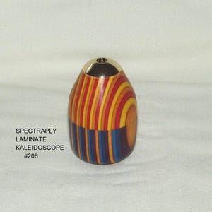 May include: A white ceramic mug with a black handle and the text "But First, Coffee" in a bold, black font. The mug is set against a blurred background, suggesting a cozy setting.