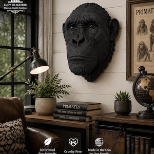 Puede incluir: Una escultura de pared tridimensional negra de una cabeza de chimpancé con rasgos faciales detallados, que incluyen pelaje texturizado, arcos superciliares prominentes y ojos realistas, exhibida como una pieza de arte decorativo.