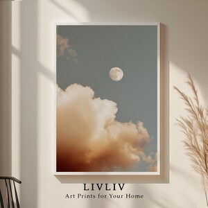 Könnte beinhalten: Ein gerahmter Kunstdruck mit einem Vollmond am blauen Himmel und pfirsichfarbenen Wolken. Der Druck hat einen weißen Rand und den Text "LIVLIV Art Prints for Your Home" unten.