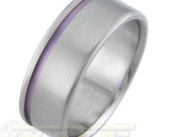 May include: A titanium ring with a purple inlay. The ring is a simple band with a smooth finish.