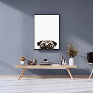 May include: A framed print of a pug dog peeking over the top of the frame. The print is hanging on a light blue wall above a wooden shelf with decorative objects.