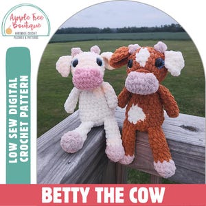 May include: Two crocheted cow plushies, one white and one brown, with pink noses and blue eyes. The plushies are sitting on a wooden railing. The text "LOW SEW DIGITAL CROCHET PATTERN" is on the left side of the image and the text "BETTY THE COW" is at the bottom of the image.