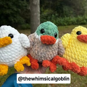 K&ouml;nnte beinhalten: Drei geh&auml;kelte Stofftiere: eine wei&szlig;e Ente, eine gelbe Ente und eine graue Ente mit gr&uuml;nem Kopf und orangefarbenem Schnabel. Die Enten sitzen alle auf einer Hand.
