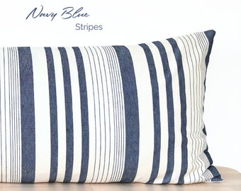 May include: A navy blue and white striped pillow with the text "Navy Blue Stripes" printed on the top.