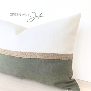 Peut inclure: Un oreiller vert et blanc avec une bordure en jute. L'oreiller est fait d'un tissu doux et texturé et a un design simple et moderne.