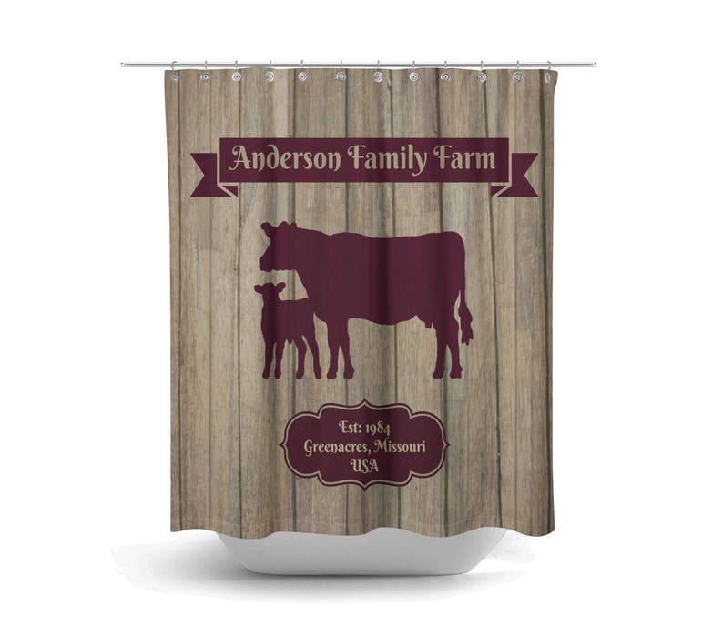 May include: A brown wooden shower curtain with a burgundy silhouette of a cow and calf. The text "Anderson Family Farm" is in a burgundy banner at the top. The text "Est. 1984 Greenacres, Missouri USA" is in a burgundy oval at the bottom.