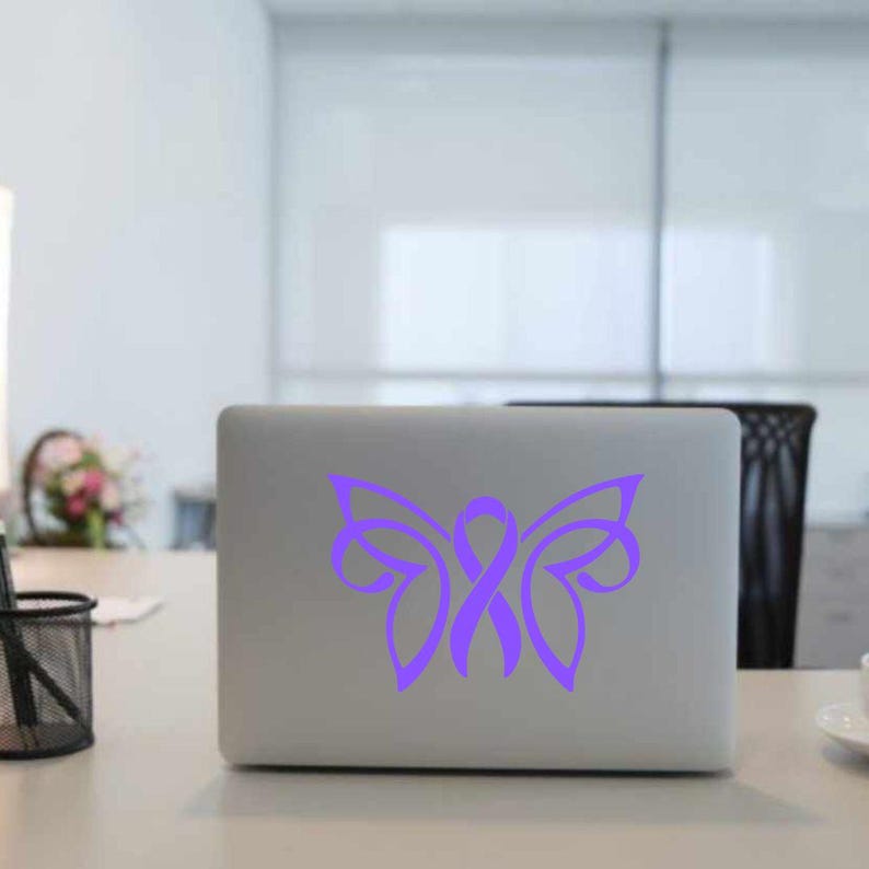 May include: A purple butterfly with a ribbon in the center, on a silver laptop.