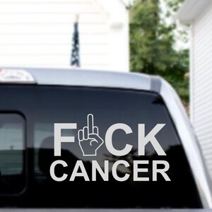 May include: A white decal with the words "F*CK CANCER" and a middle finger symbol on a black car window.