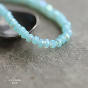 May include: A delicate bracelet made of light blue faceted beads. The beads are strung together to form a simple, elegant design.
