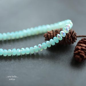 Semi translucent milky sky blue opaline glass with a 1/2 coat rainbow Aurora Borealis and fire polished finish .. lots of flash and sparkle .. great little spacer accent beads.
Mystic Sky Bits
