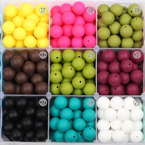 Pode incluir: Um organizador de plástico cheio de contas redondas coloridas em várias tonalidades. As cores incluem azul claro, amarelo, rosa, verde oliva, creme, castanho, verde limão, bordô, vermelho, azul, preto, verde-azulado, branco e verde menta.