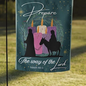 May include: A teal garden flag with the words "Prepare" and "The way of the Lord" in white script. The flag features a wreath, candles, and silhouettes of figures, with the text "Isaiah 40:3".