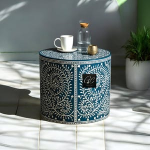 May include: A round blue and white side table with a floral design. The table is made of wood and has a white inlay. The table is 46 cm in diameter and 46 cm tall. The table is perfect for a living room or bedroom.