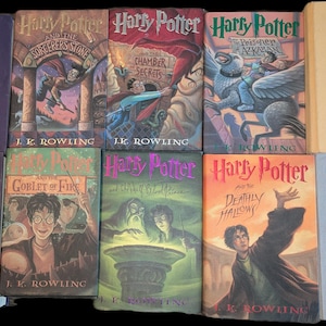 Op de afbeelding: Een verzameling Harry Potter-boeken, met verschillende covers met illustraties en titels. De boeken zijn gerangschikt in een raster, met de iconische beelden van de serie en auteur J.K. Rowling.
