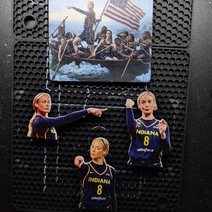 May include: A square print and three die-cut stickers featuring a basketball player in a navy blue Indiana jersey with the number 8. The print depicts the player in a boat with a team, holding an American flag. The stickers show the player pointing.