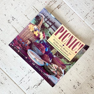 Ricettario vintage del 1990, cestino da picnic, tagliere di salumi, libro di ricette, viaggio, cena all&#39;aperto