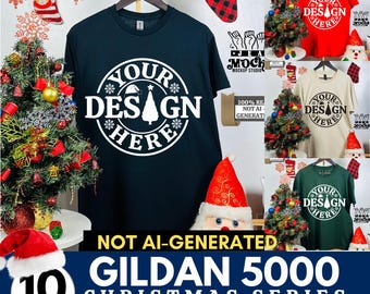 May include: Mockup bundle of 10 different color Gildan 5000 t-shirts with a Christmas design. The design features a white circle with the text "Your Design Here" and a stylized Christmas tree inside the circle. The t-shirts are displayed on a white background with Christmas decorations.